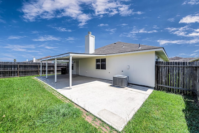 rear view of house featuring a patio, central AC, and a lawn