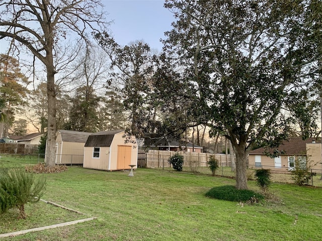 view of yard featuring a storage unit, fence private yard, and an outdoor structure