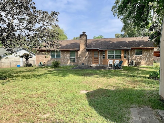 back of house featuring brick siding, a patio, a chimney, and a shingled roof