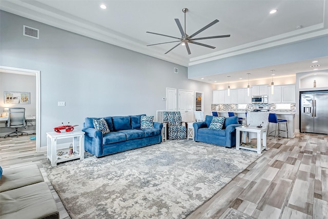 living room with ceiling fan and light wood-type flooring