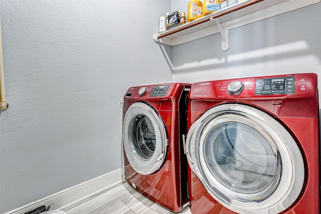 laundry area with separate washer and dryer and light hardwood / wood-style floors