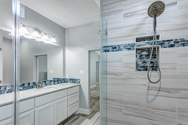 bathroom featuring a tile shower, vanity, and hardwood / wood-style flooring