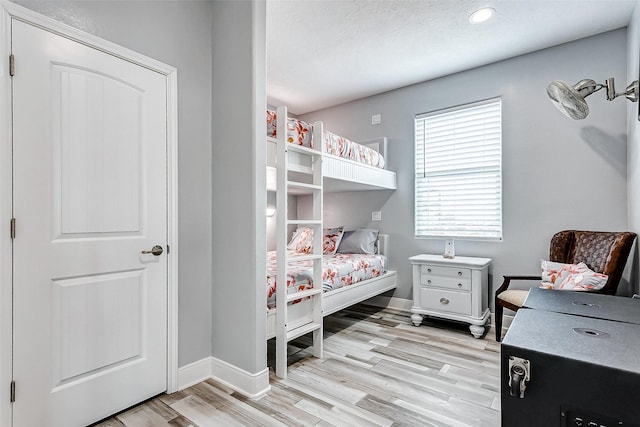 bedroom featuring light hardwood / wood-style floors and a textured ceiling