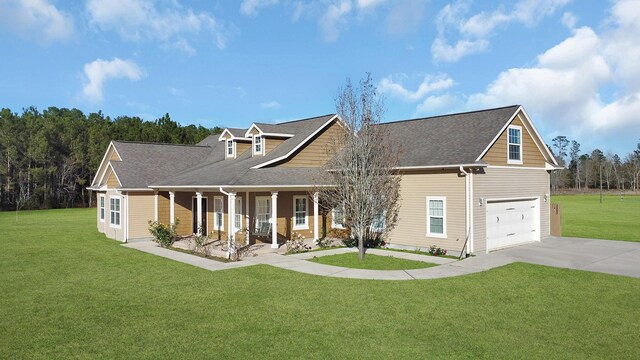 view of front of property with a garage, covered porch, and a front lawn