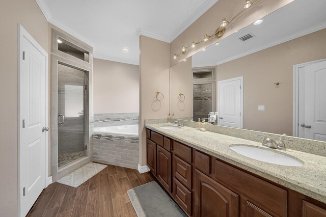 bathroom with vanity, crown molding, plus walk in shower, and hardwood / wood-style flooring