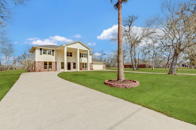 view of front of property featuring a garage, a front yard, a balcony, and covered porch