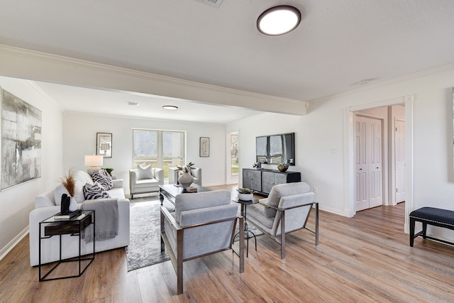 living room with ornamental molding and light hardwood / wood-style floors