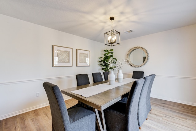 dining area featuring an inviting chandelier and light hardwood / wood-style floors