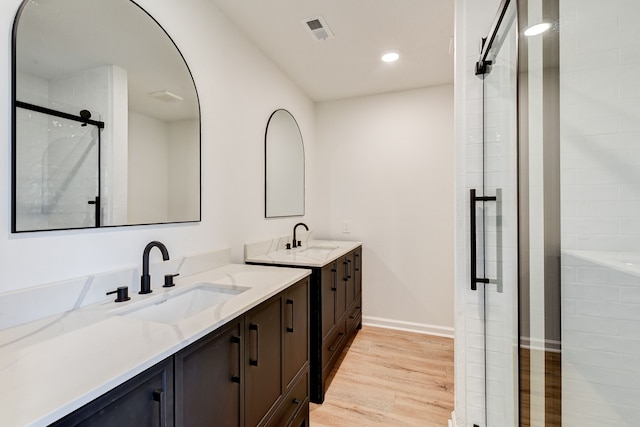 bathroom with vanity, an enclosed shower, and wood-type flooring