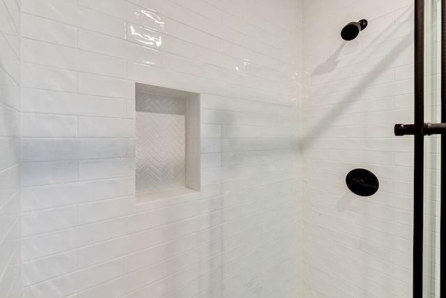 interior details featuring tiled shower