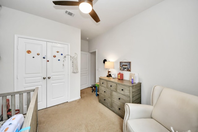 bedroom with ceiling fan, light colored carpet, and a closet