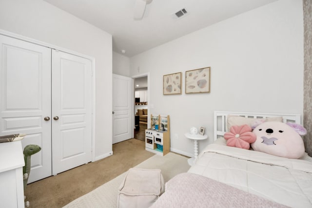 bedroom with light colored carpet, a closet, and ceiling fan