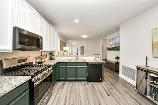 kitchen with white cabinetry, sink, kitchen peninsula, stainless steel appliances, and light hardwood / wood-style flooring