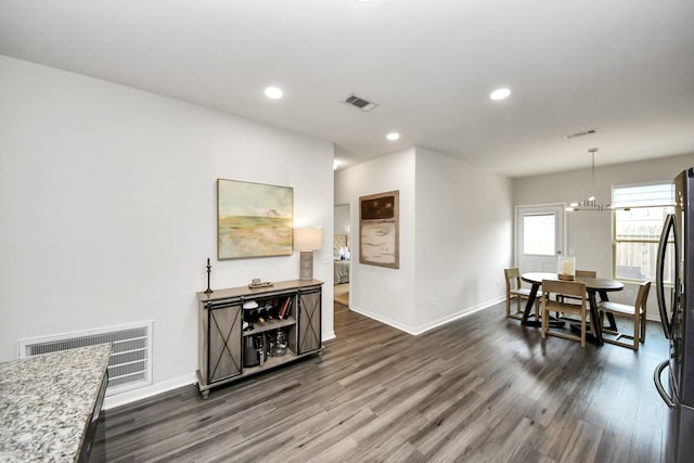 dining area featuring dark hardwood / wood-style flooring and a chandelier