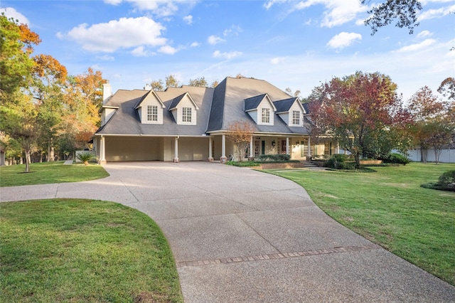 cape cod-style house featuring a garage, covered porch, and a front yard