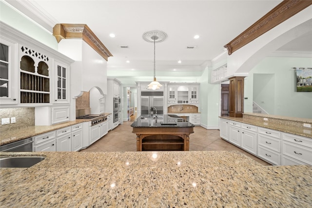 kitchen featuring appliances with stainless steel finishes, sink, white cabinets, and decorative light fixtures