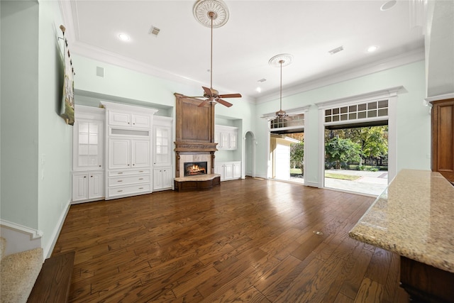 unfurnished living room with crown molding, ceiling fan, and dark hardwood / wood-style flooring