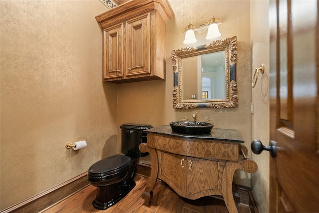 bathroom with vanity, toilet, and hardwood / wood-style floors