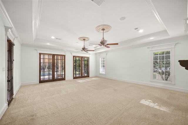 unfurnished room featuring crown molding, light colored carpet, and a raised ceiling