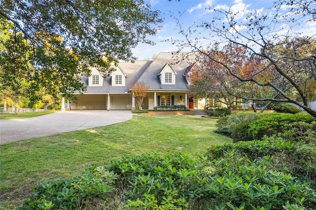 new england style home with a garage, a front lawn, and a porch