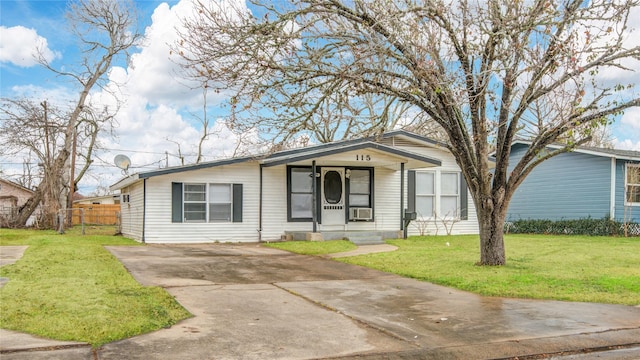 single story home featuring cooling unit, a front lawn, and covered porch