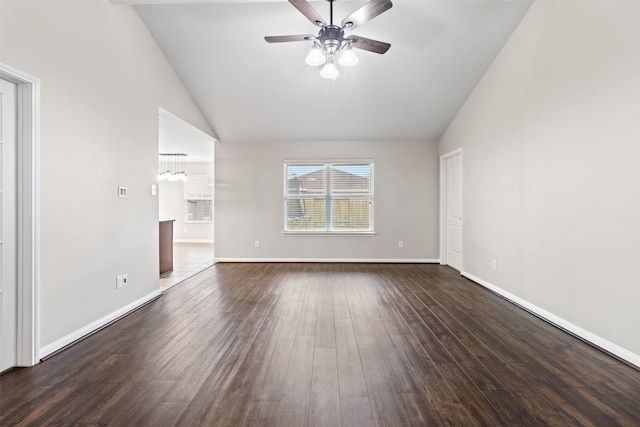 unfurnished room featuring dark wood-type flooring, high vaulted ceiling, and ceiling fan with notable chandelier