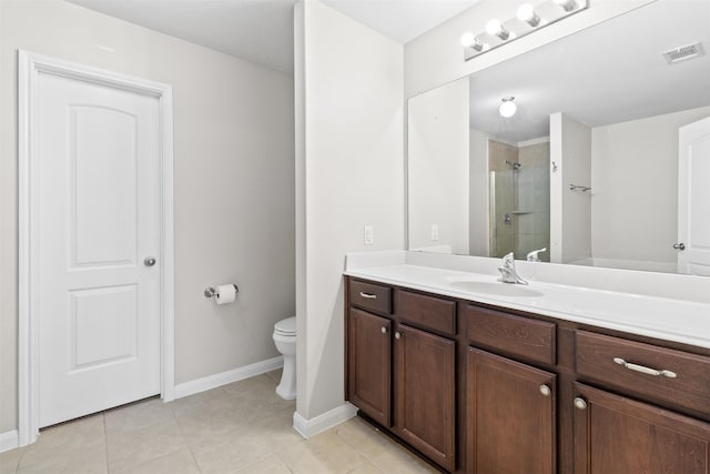 bathroom featuring a shower with door, vanity, tile patterned flooring, and toilet