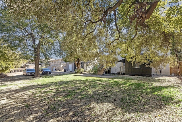 view of property hidden behind natural elements featuring a front yard