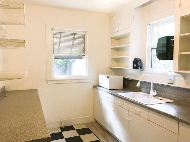 1632 W Alabama St, Houston, TX 77006 - kitchen featuring open shelves, a sink, dark countertops, light floors, and white microwave