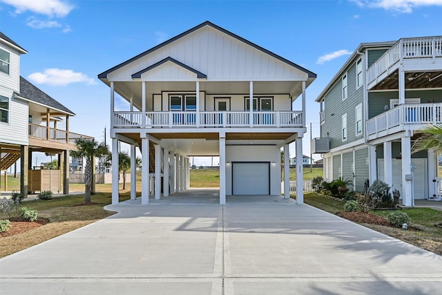 raised beach house with a garage, a carport, and covered porch