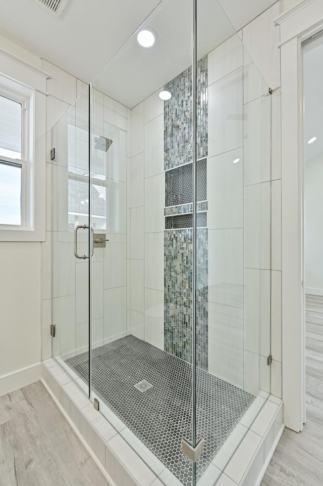 bathroom featuring hardwood / wood-style flooring and a shower with shower door