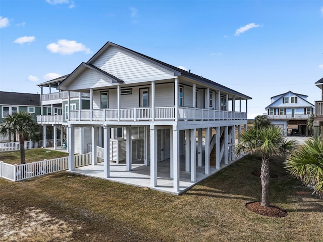 back of house featuring a carport, a balcony, and a lawn