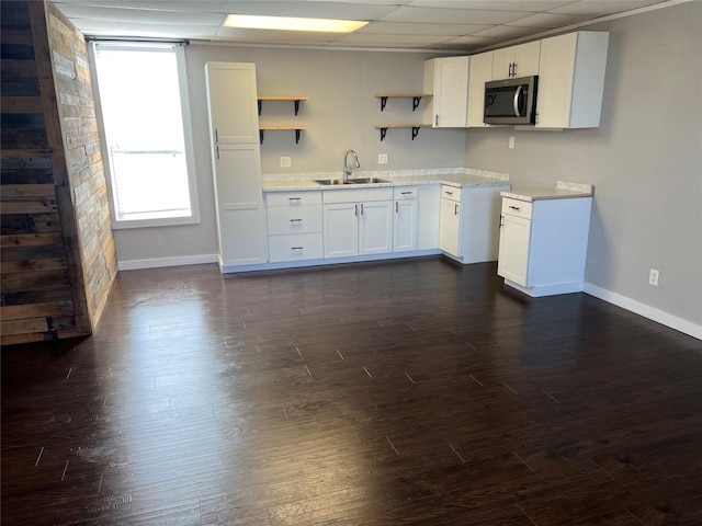 kitchen featuring a paneled ceiling, dark hardwood / wood-style floors, sink, and white cabinets