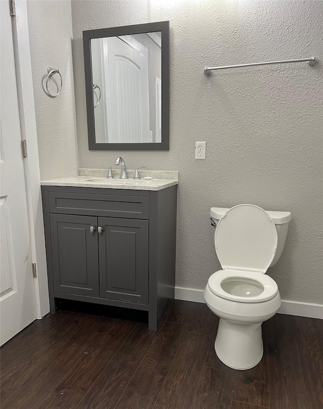 bathroom featuring vanity, hardwood / wood-style floors, and toilet