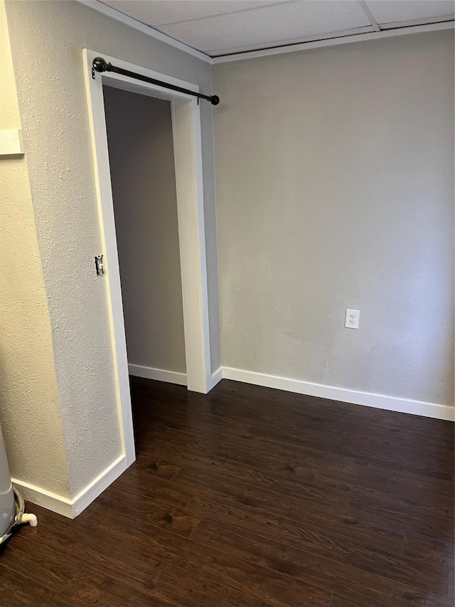 unfurnished room with dark wood-type flooring and a barn door