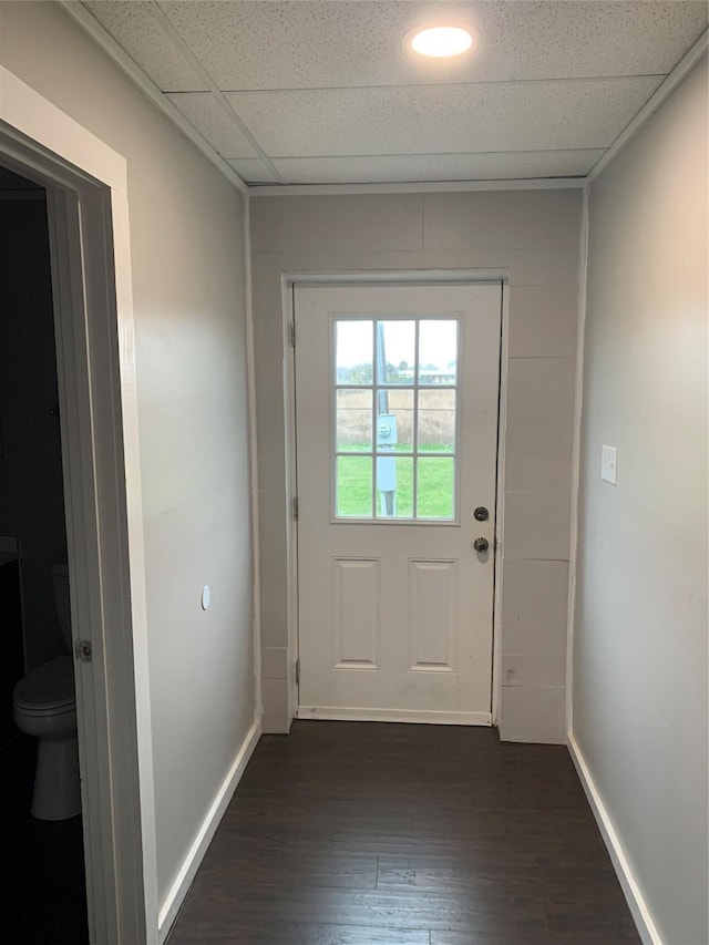 doorway to outside with dark wood-type flooring and a drop ceiling