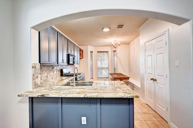 kitchen featuring sink, light stone counters, light tile patterned floors, kitchen peninsula, and backsplash