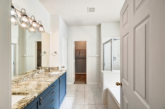 bathroom featuring a shower with door, vanity, and tile patterned flooring