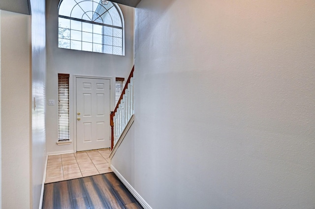 entrance foyer featuring a towering ceiling and light wood-type flooring