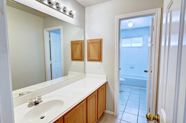 full bathroom featuring vanity, tiled shower / bath, tile patterned floors, and toilet