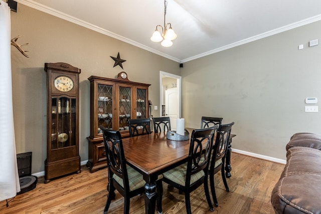 dining area featuring ornamental molding, light hardwood / wood-style floors, and a notable chandelier