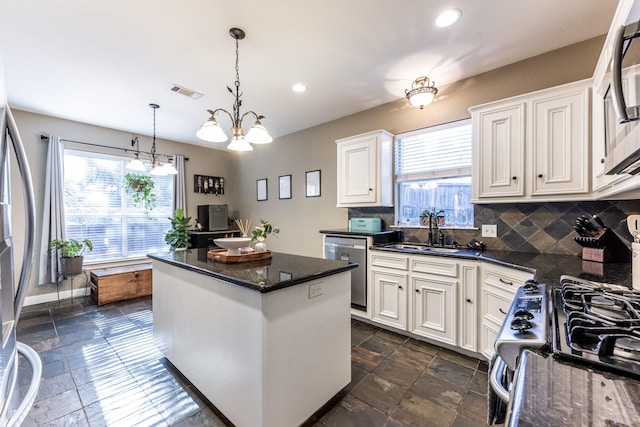 kitchen featuring sink, decorative light fixtures, white cabinets, and appliances with stainless steel finishes