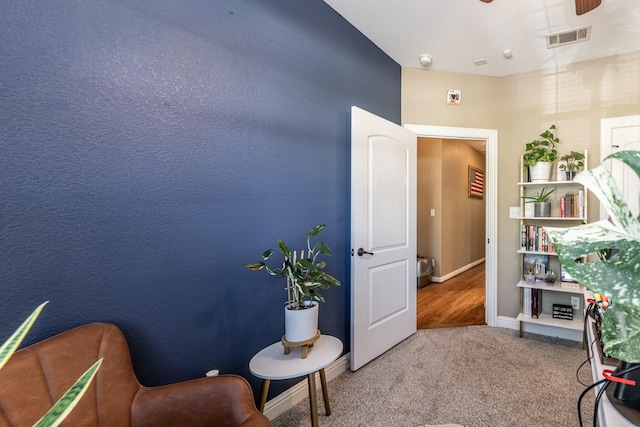 sitting room with carpet and ceiling fan