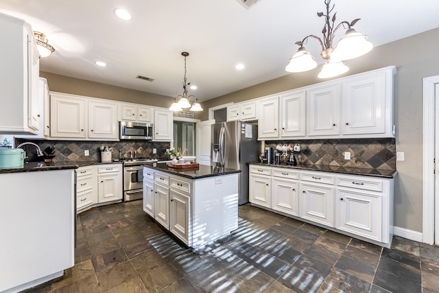 kitchen featuring white cabinetry, appliances with stainless steel finishes, a center island, and pendant lighting