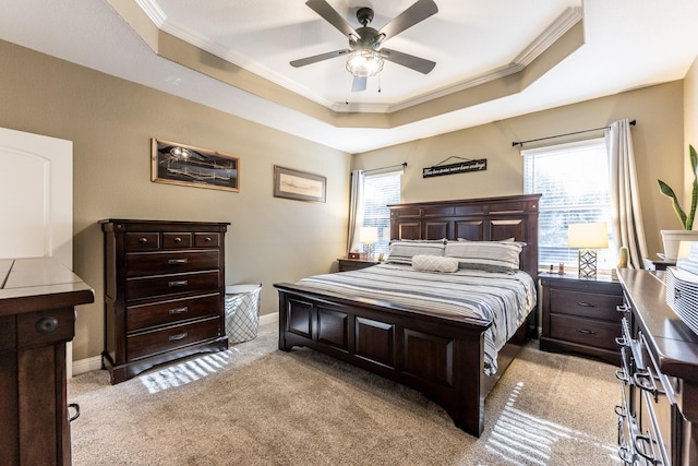 carpeted bedroom featuring multiple windows, ornamental molding, and a tray ceiling