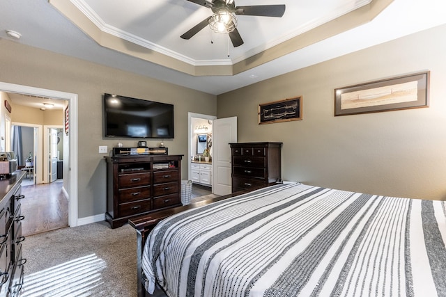 bedroom with connected bathroom, crown molding, carpet flooring, a tray ceiling, and ceiling fan