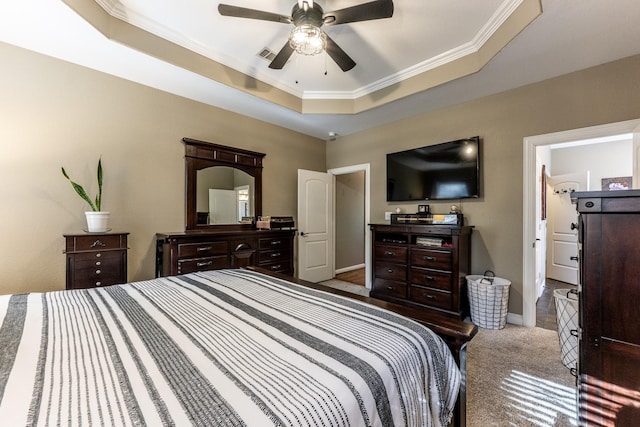 bedroom featuring ceiling fan, ornamental molding, a tray ceiling, and light carpet