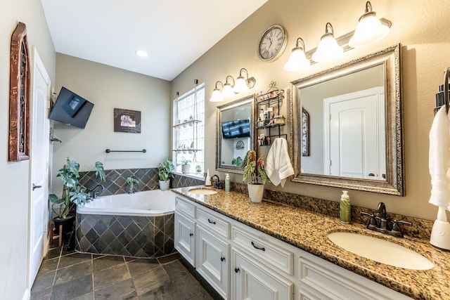 bathroom with tiled tub and vanity