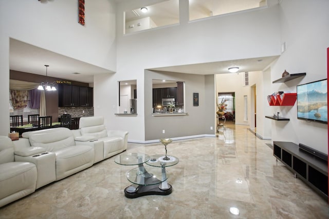 living room featuring an inviting chandelier and a towering ceiling