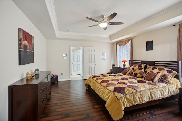 bedroom with dark hardwood / wood-style floors, ceiling fan, a tray ceiling, and crown molding